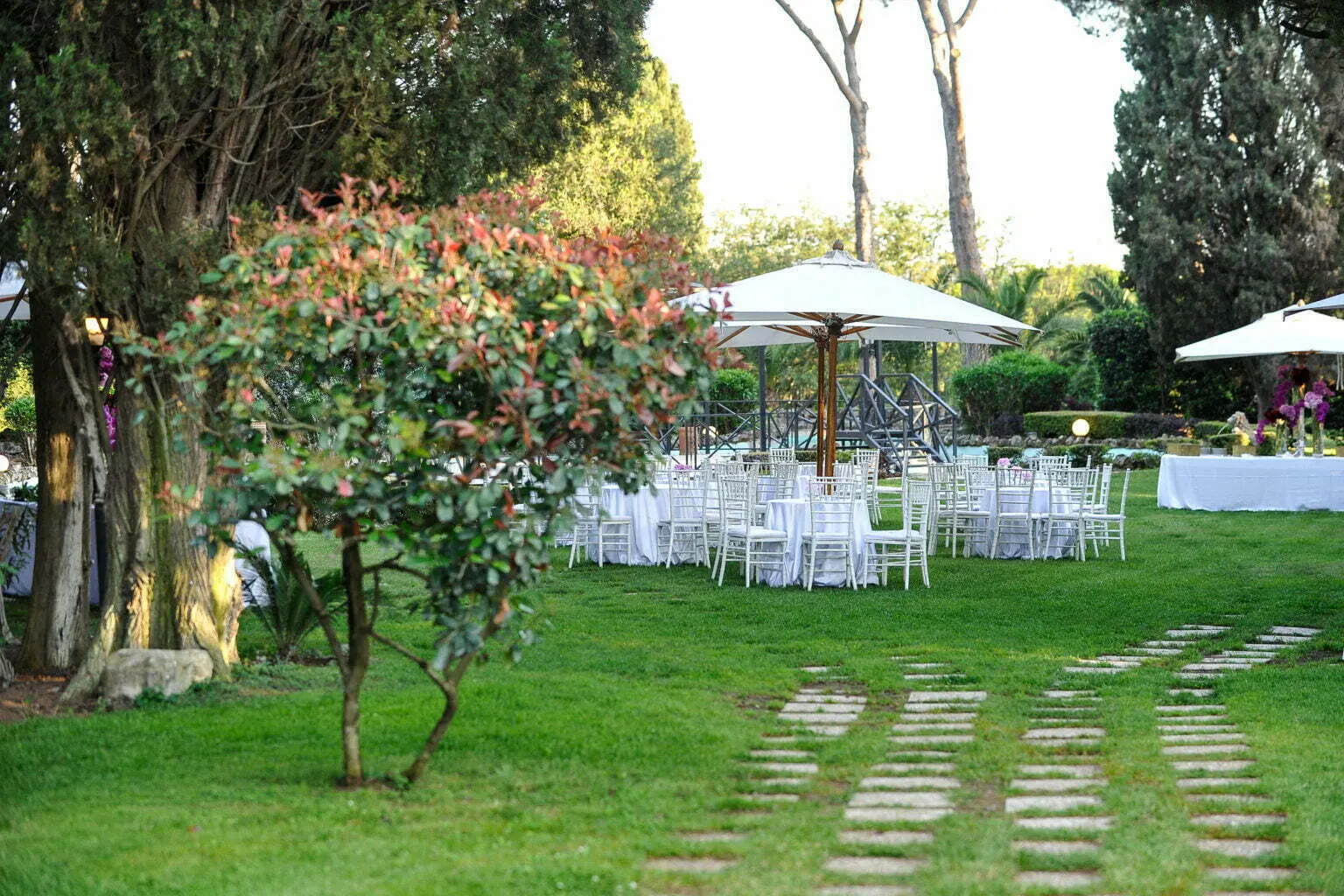 Tavoli apparecchiati sotto gli alberi del parco secolare